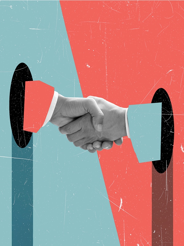 Two hands reach through oval holes in a red and blue split background and shake hands, symbolizing agreement or partnership. The arms and sleeves are color-matched with the background halves.